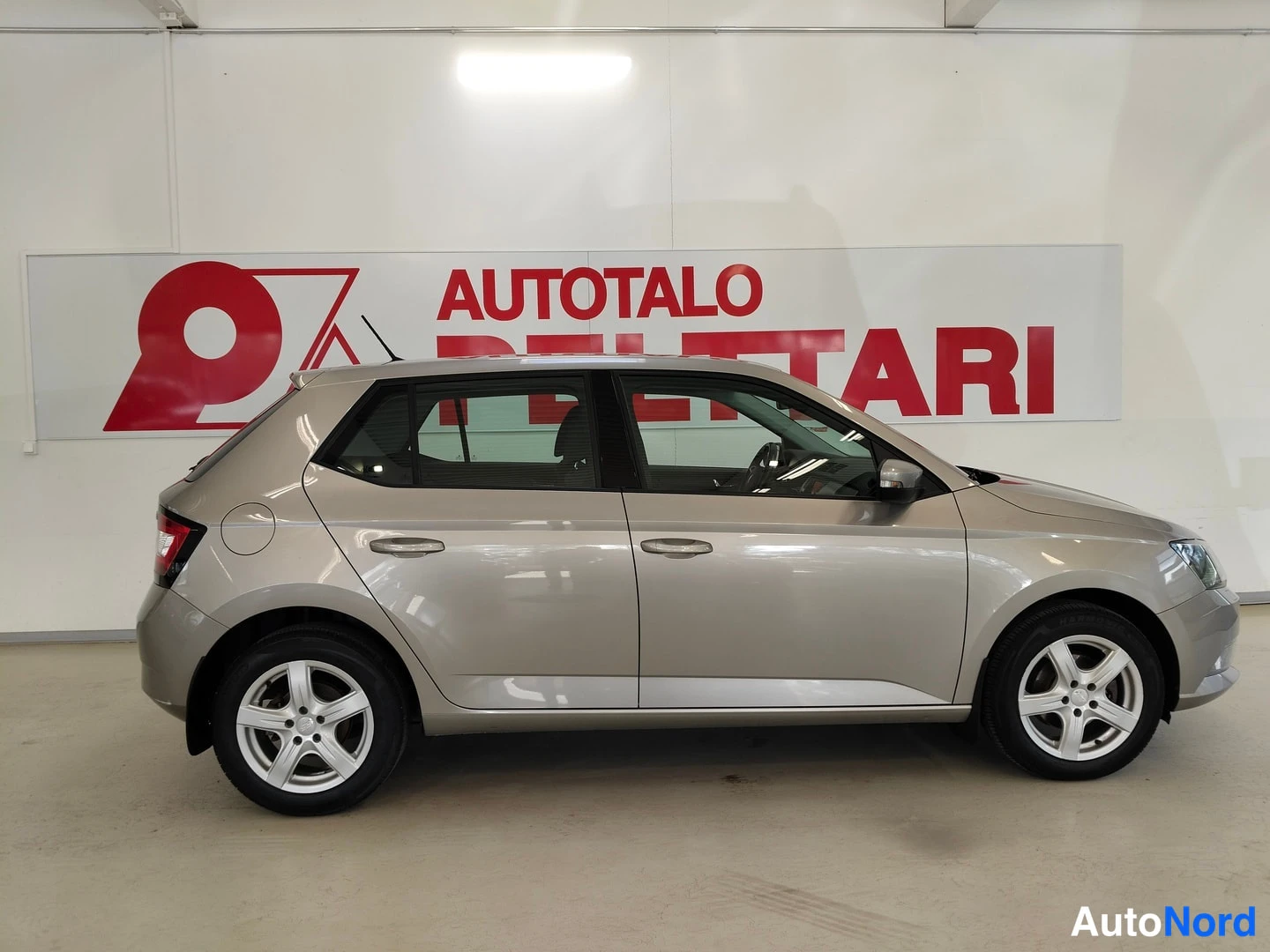 Sivulta: Skoda Fabia sivulta nähtynä sisätiloissa, viisiovinen hatchback, hopeanbeige maali.