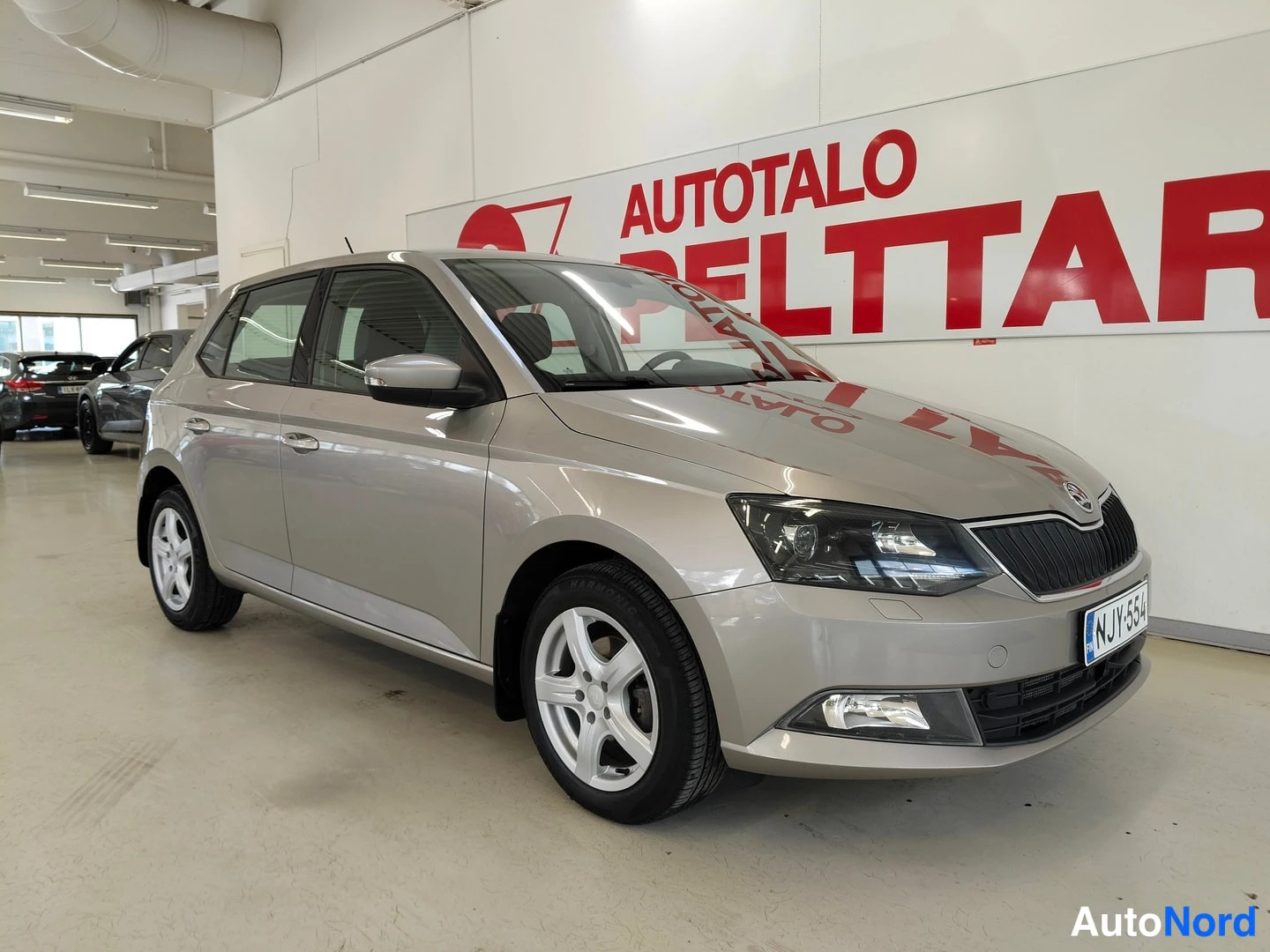 Etuviisto, nokka oikealle: Skoda Fabia etuviistöstä oikealta nähtynä sisätiloissa, keula ja etusäleikkö sekä oikea kylki näkyvissä, rekisterikilpi.