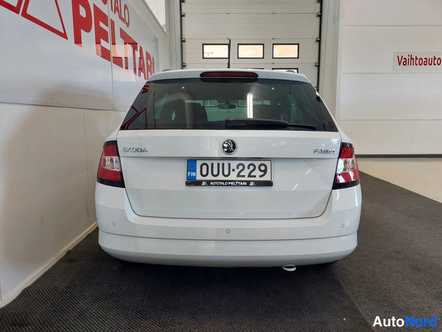 Takaa: Valkoinen Skoda Fabia Combi takaa nähtynä, rekisterikilpi.