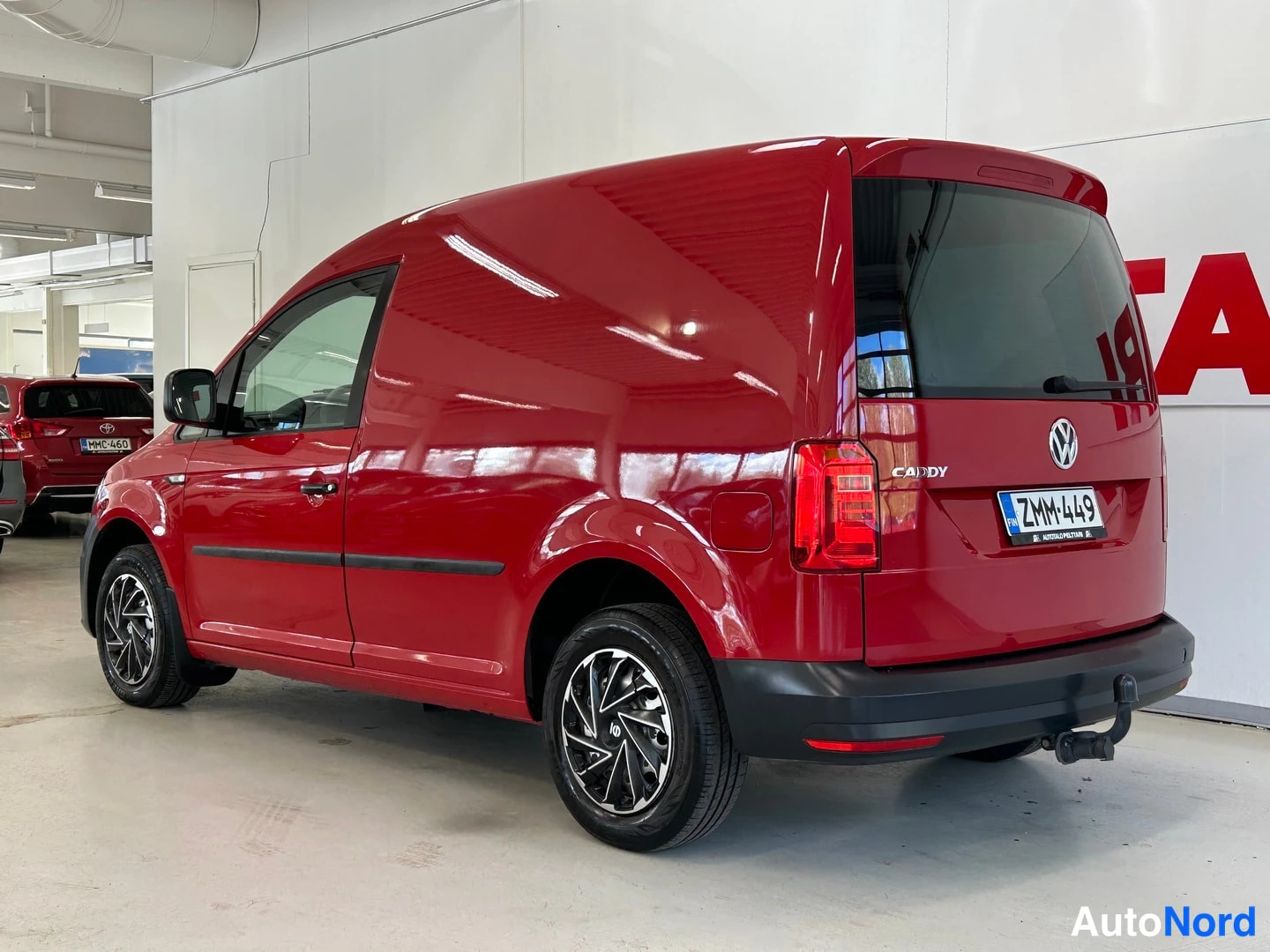 Takaviisto: Punainen pakettiauto takakulmasta; perävasen kylki näkyvissä, rekisteri.