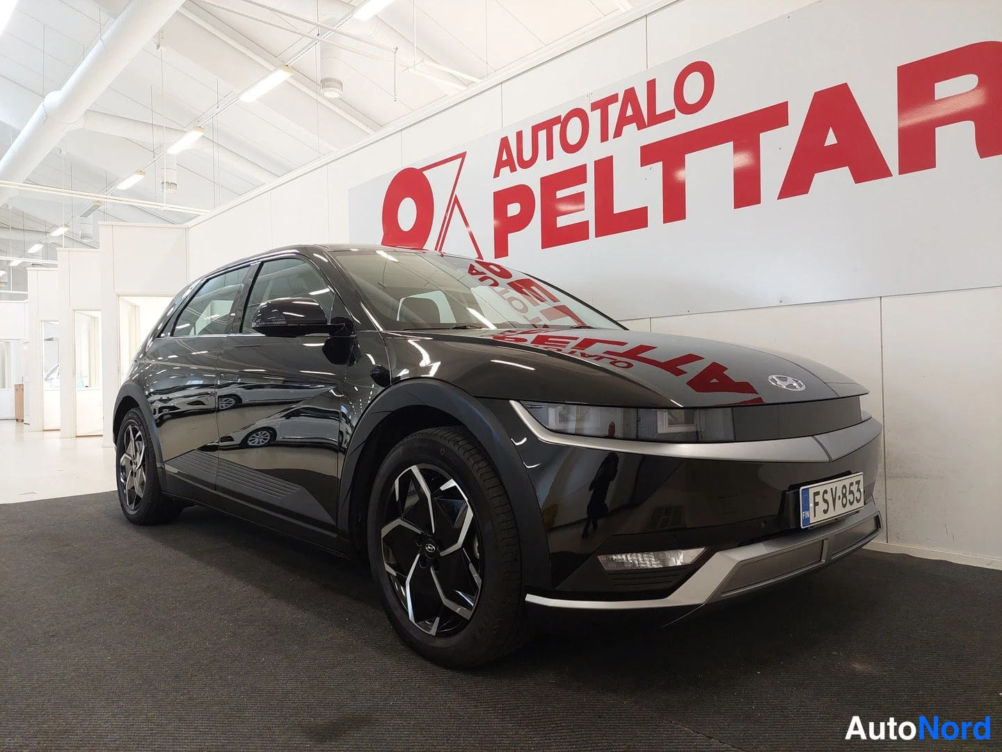 Etuviisto, nokka oikealle: Auton etunurkka, musta crossover showroomissa