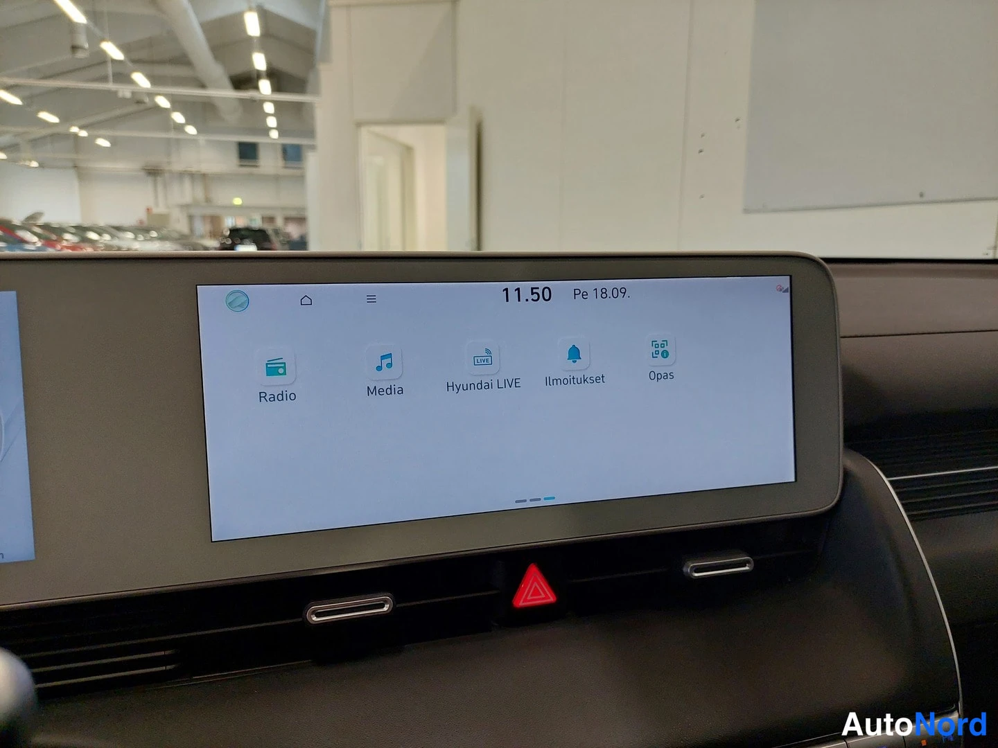 Yksityiskohta: Kojelaudan infotainmentnäyttö, jossa Radio-, Media-, Hyundai LIVE-, Ilmoitukset- ja Opas-valikot sekä kellonaika 11.50 ja päivämäärä Pe 18.09.