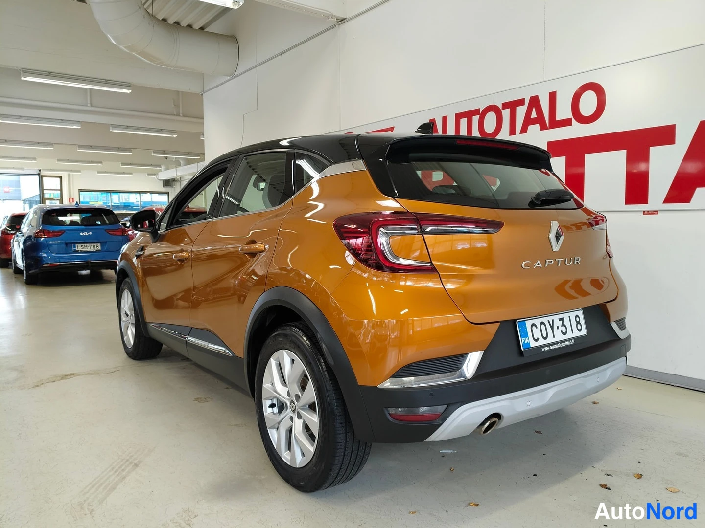 Takaviisto: Renault Capturin takakulmanäyttö: oranssi kori, musta katto, CAPTUR-teksti ja rekisteri sisätiloissa.