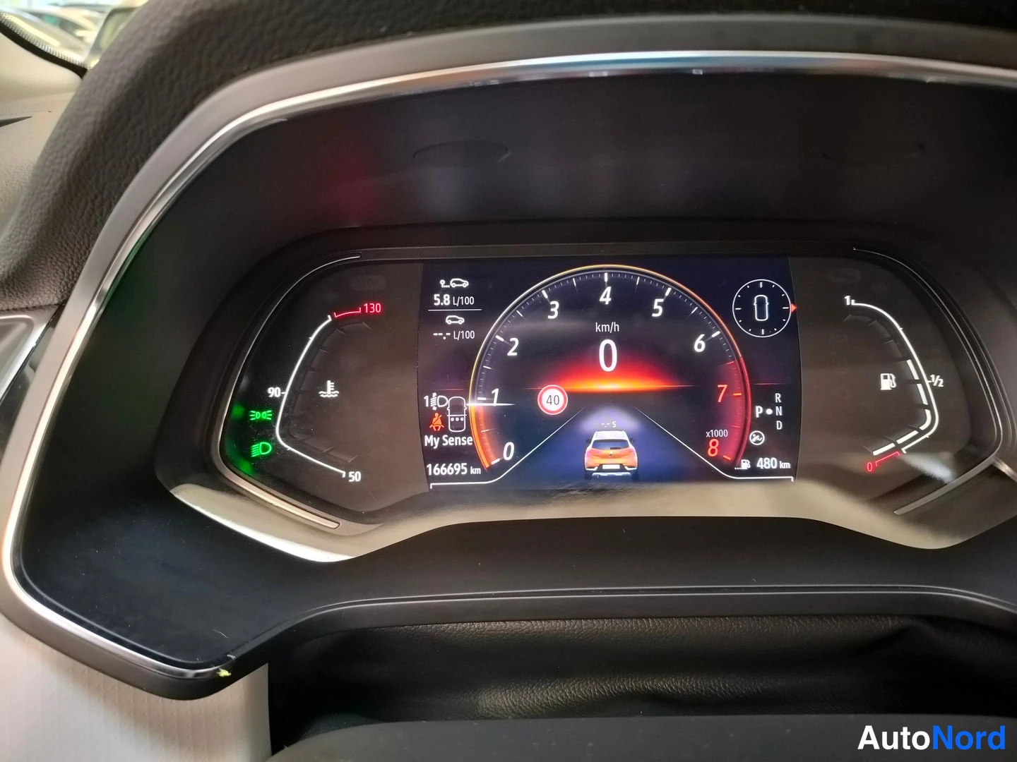 Muu: Renaultin digitaalinen mittaristo, jossa kilometrilukema 166 695 km ja polttoainemittarin vasen puolisko näkyvissä.