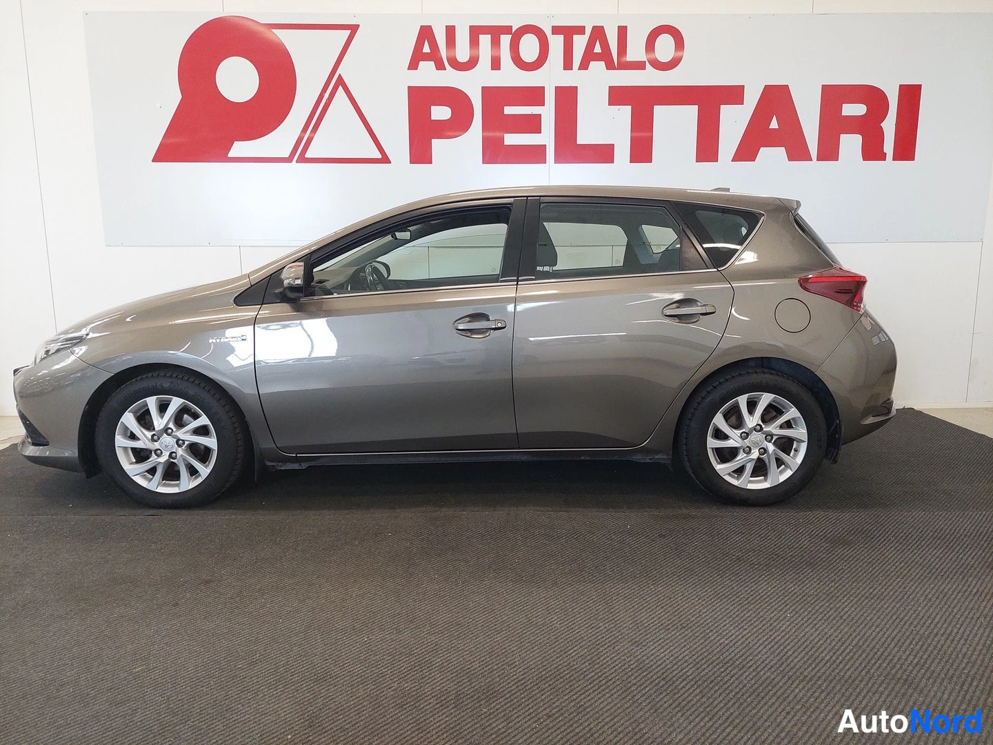 Sivulta: Ruskeanharmaa Toyota Auris sivulta autonhallissa