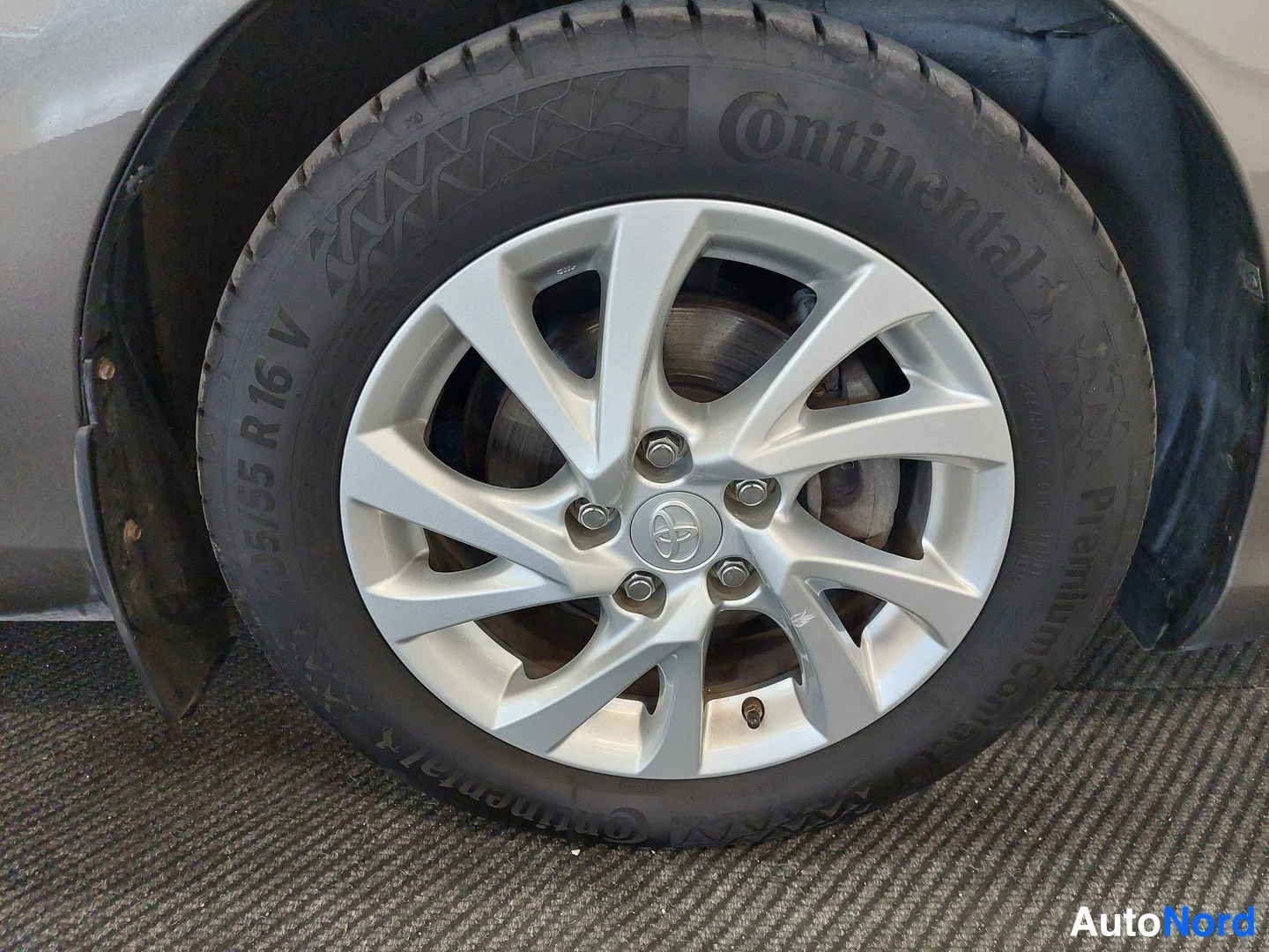 Yksityiskohta: auton renkaan lähikuva, hopeavanne, Continental PremiumContact-rengas, koko 205/55 R 16 V