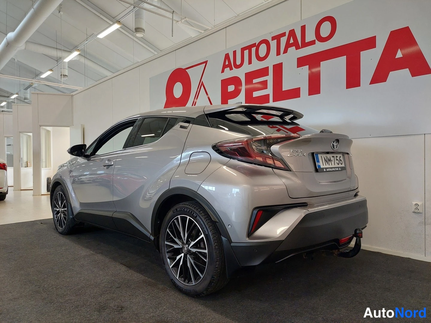 Takaviisto: Hopeanvärisen Toyota C-HR:n takaosa ja oikea kylki rekisteritunnuksella.