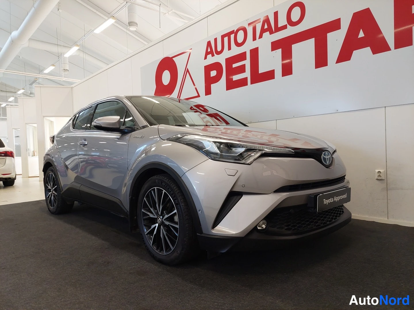 Etuviisto, nokka oikealle: Auto etuosa kolmanneltu vasemmalta, keulan keskihalkaisija on oikealla, keulavalaistus ja Toyota-merkki näkyvät.