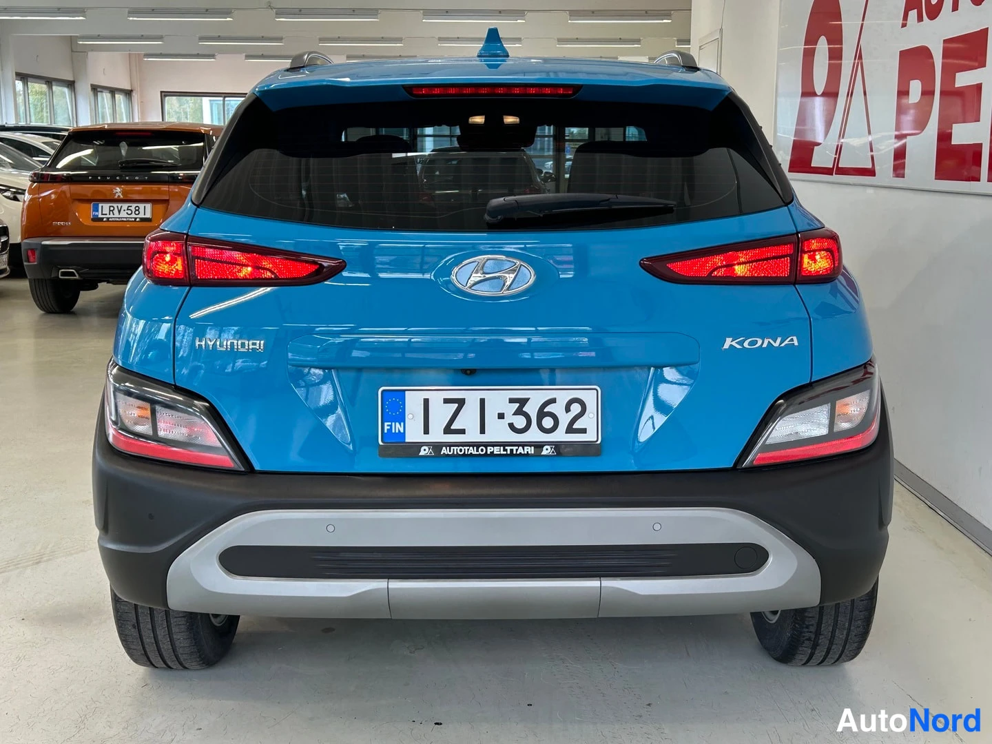 Takaa: Sininen Hyundai Kona suoraan takaa valot palleet, rekisteritunnus.