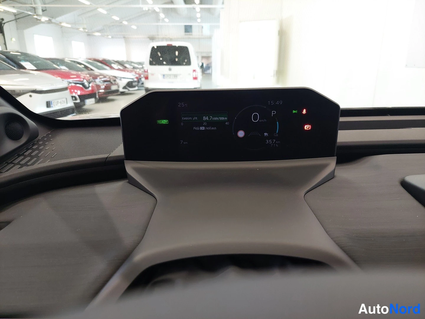 Takaa: Mittaristön näyttö lähikuvassa: nolla km/h, P-vaihde, READY-merkki, 357 km toimintamatka ja keskikulutus 84,7 kWh/100km.