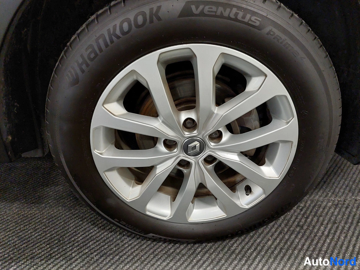 Yksityiskohta: Hopeinen kevytmetallivanne Renault-logolla ja Hankook Ventus Prime -kesärengas.