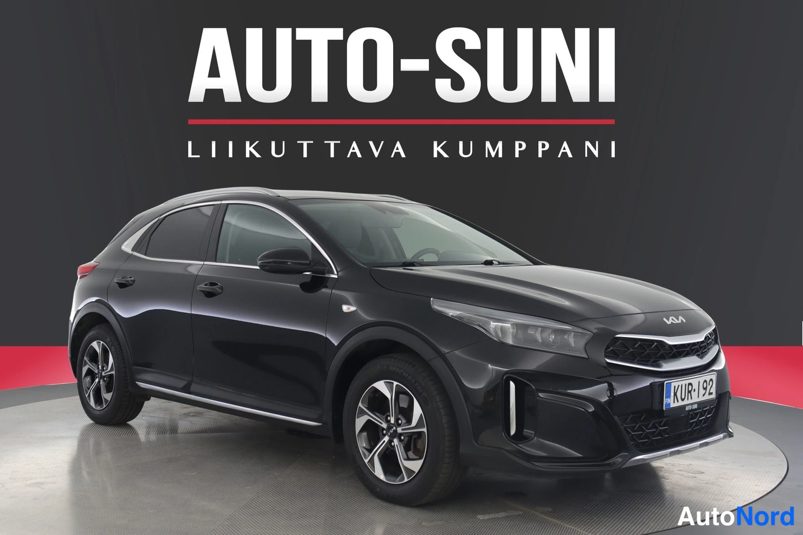 Etuviisto, nokka oikealle: Musta Kia XCeed -maasturin näköinen hatchback etukulmasta, keulakoodi ja kylki näkyvät, rekisteritunnus.