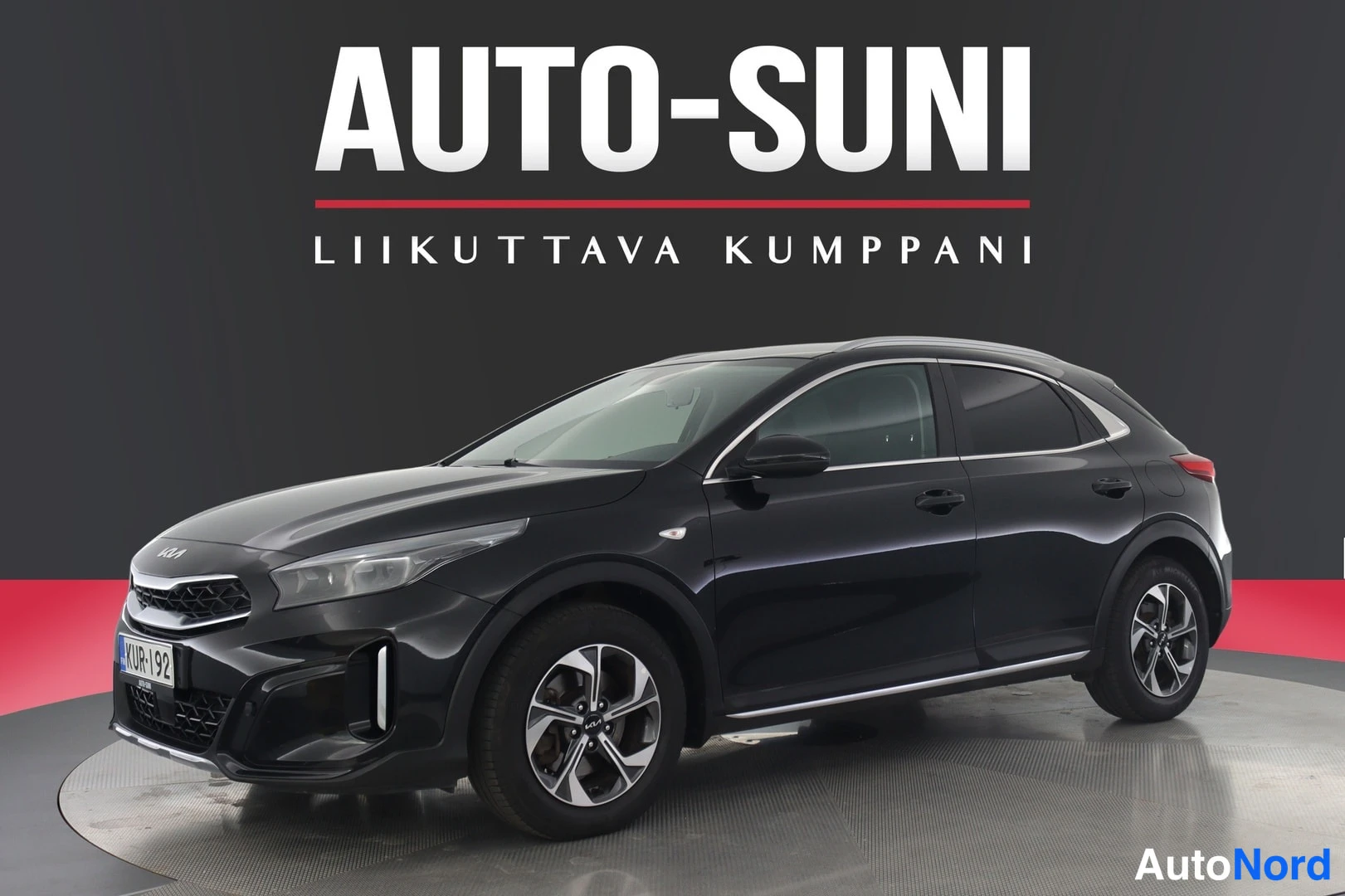Etuviisto, nokka vasemmalle: Musta Kia XCeed -henkilöauto kolmea neljäsosaa edestä vasemmalta kuvattuna studiotaustaa vasten.