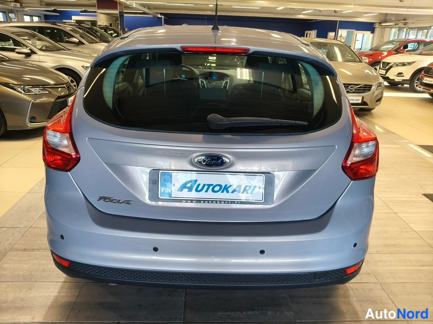 Takaa: Auton takaosa suoraan takaa kuvattuna: punaiset takavalot, takaluukku Ford- ja Focus-merkeillä, Autokari-tunnus nokassa sekä puskurin pyöreät tutka-anturit.