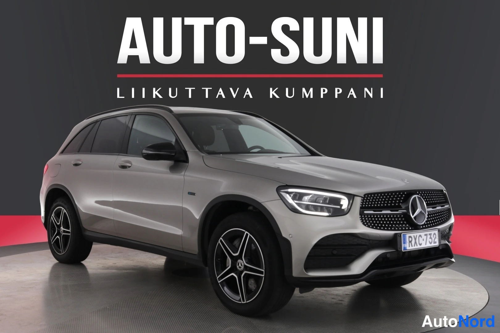 Etuviisto, nokka oikealle: Autosivuissa auto etukulmasta oikealta: hopeanharmaa Mercedes-Benz GLC, kylki ja etusäleikkö näkyvissä.