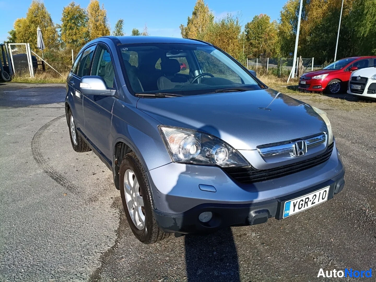 Etuviisto, nokka oikealle: Hopeansininen Honda CR-V etuviistosta vasemmalta, rekisteritunnus.