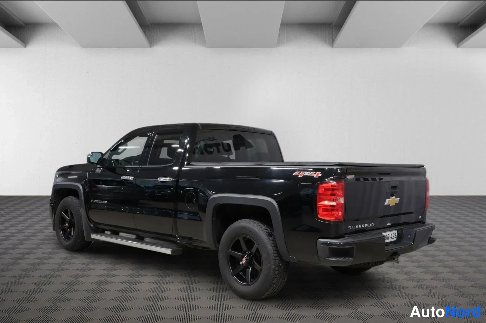 Takaviisto: Mustan Chevrolet Silverado -avolavan takakulman kuva, takaosassa näkyy 4x4-merkki.