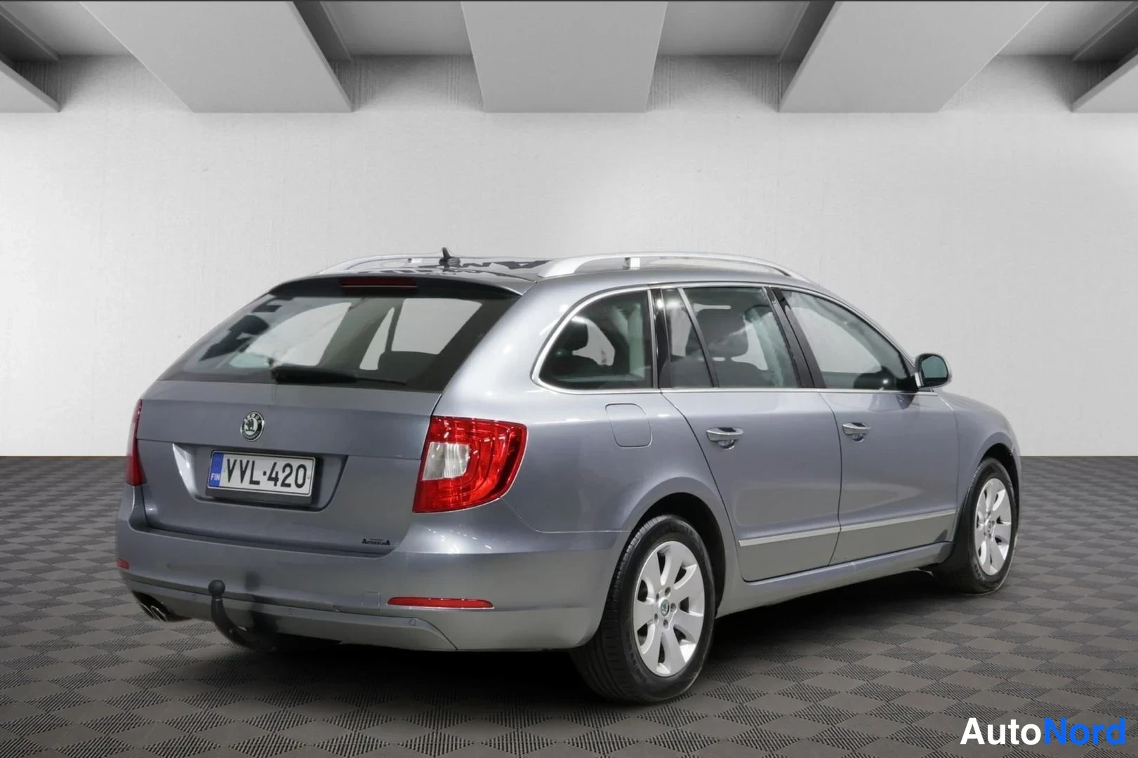 Takaviisto: Skoda Superb -farmariauto takaa sivusta, hopeaharmaa kori ja rekisteri.