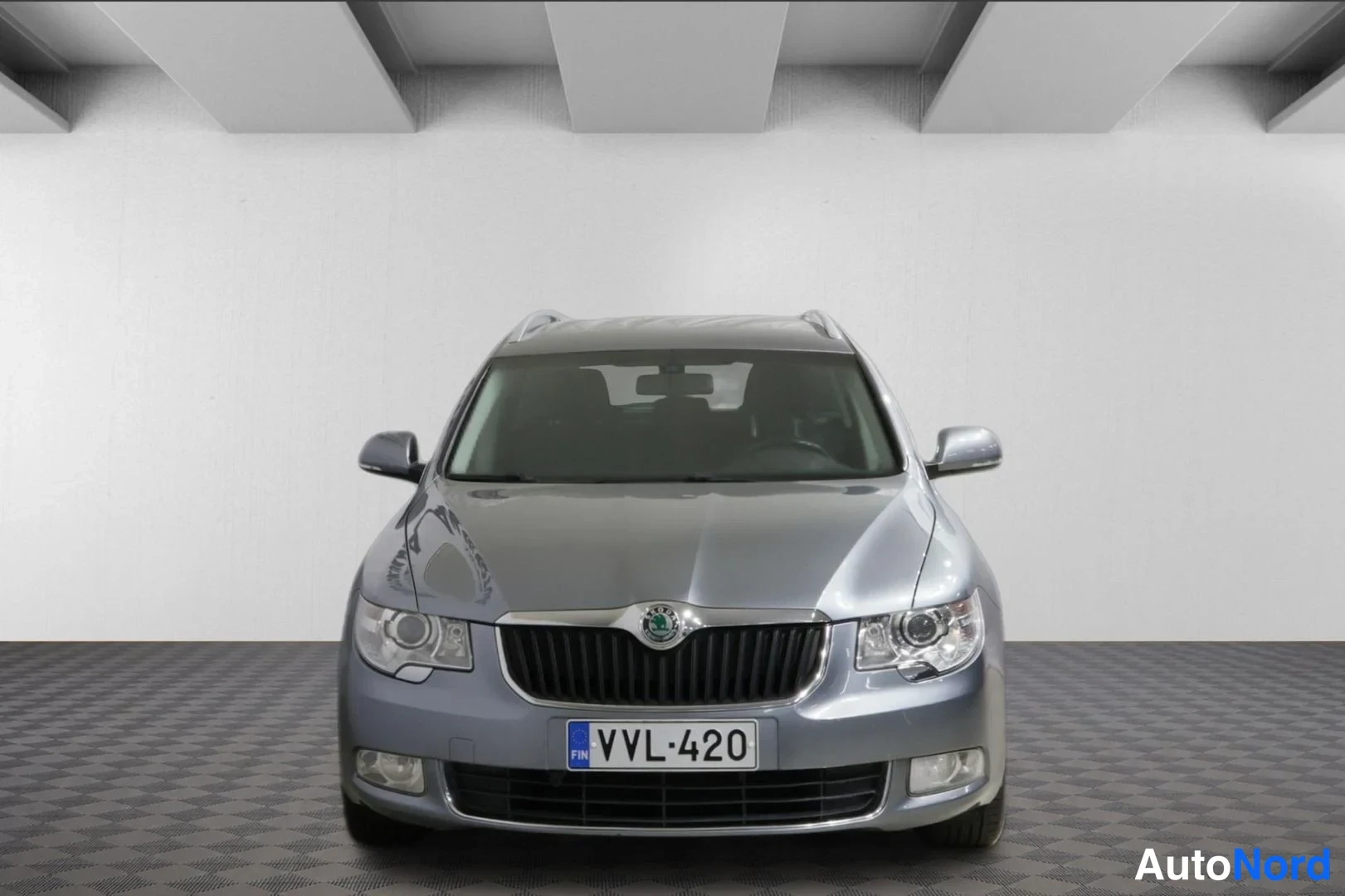 Edestä: Skoda Superb -farmariauto suoraan edestäpäin, etusäleikkö ja rekisteri.