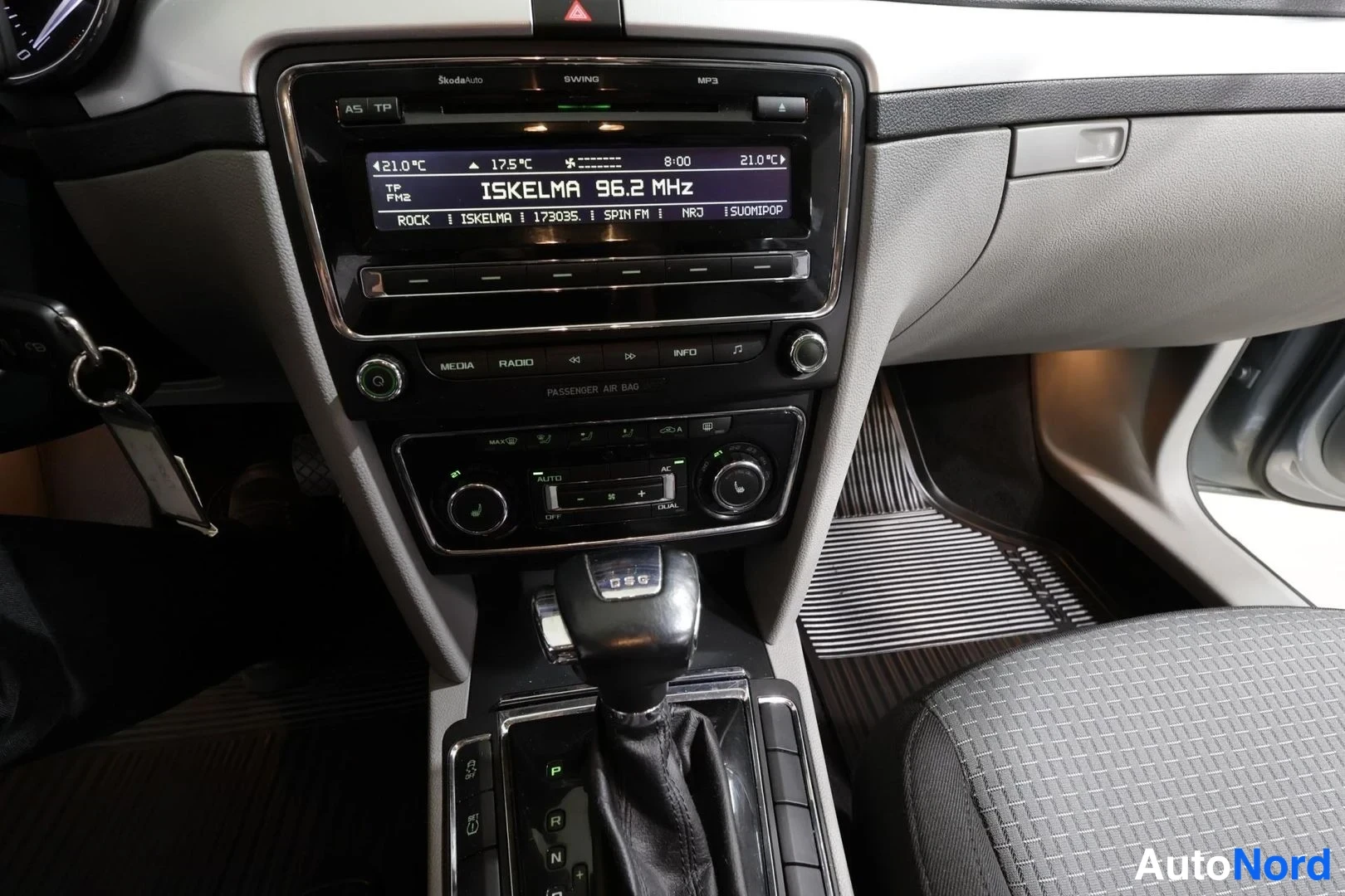 Muu: Keskikonsoli: radio näyttää kanavan ISKELMA 96.2 MHz, alla automaattinen kaksipaikkainen ilmastointi (AUTO, DUAL) ja DSG-vaihteenvalitsin.