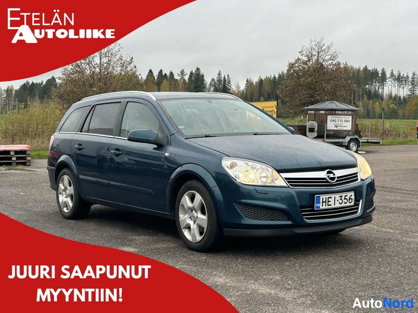 Etuviisto, nokka oikealle: Opel Astra -farmari tummansinisessä värisävyssä, etukulmakuva oikeaan osoittavana, rekisteritunnus.
