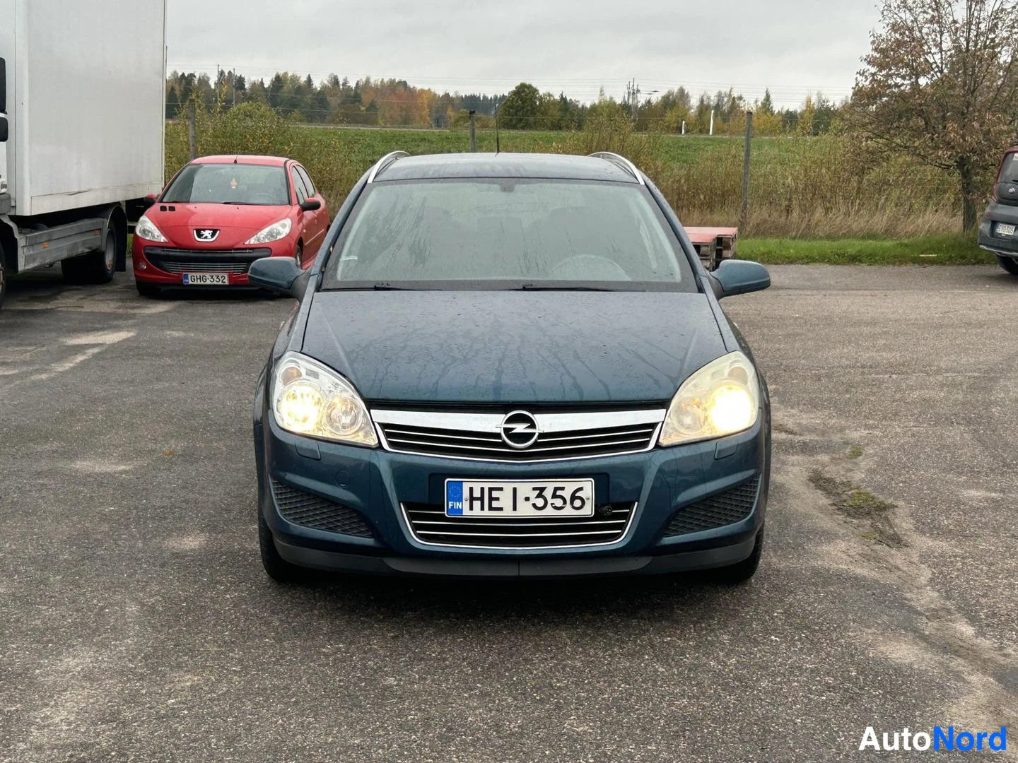 Edestä: Opel Astra etusuora valot päällä, rekisteritunnus.