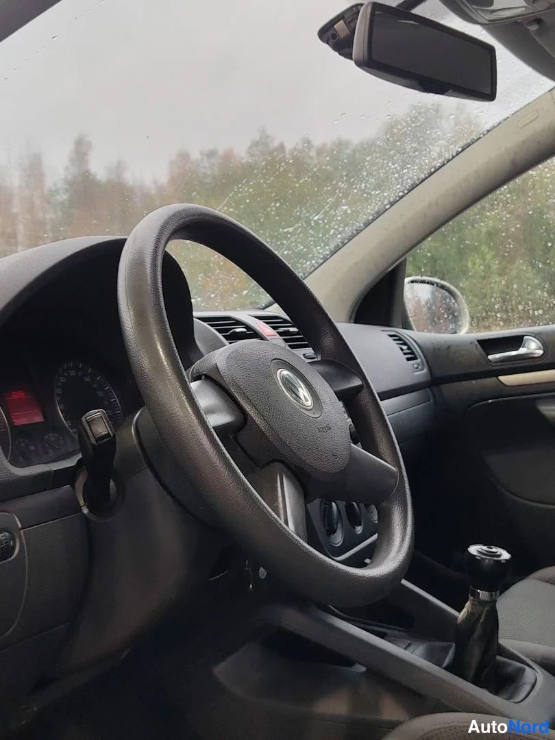 Muu: Ohjaamo sisäpuolelta: Volkswagen-merkkinen ohjauspyörä, mittaristo ja manuaalivaihteen vaihdekeppi.