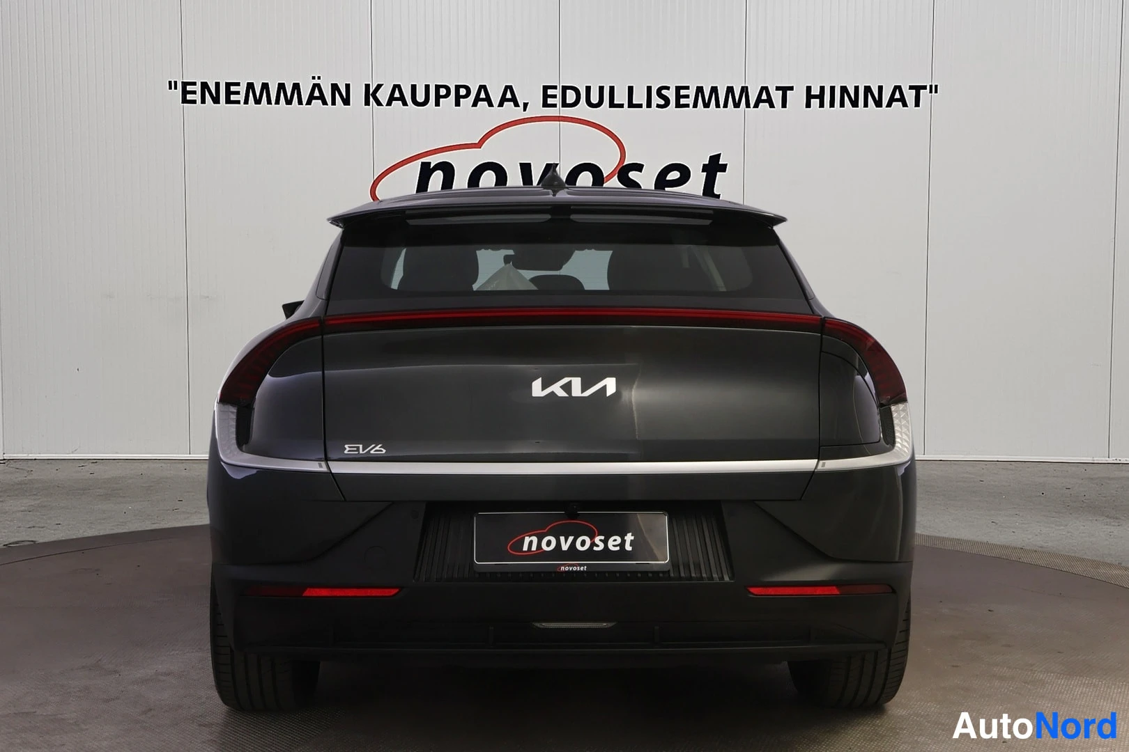 Takaa: Kia EV6 suoraan takaa; KIA-logo, EV6-tunnus ja punainen takavalokoru näkyvät.
