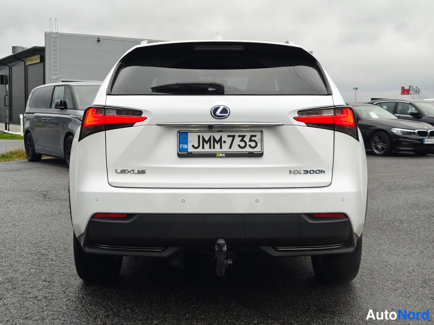 Takaa: Valkoisen Lexus NX 300h:n takaosa suoraan takaa; rekisteritunnus, Lexus-merkki ja perävaikkukoukku näkyvät.