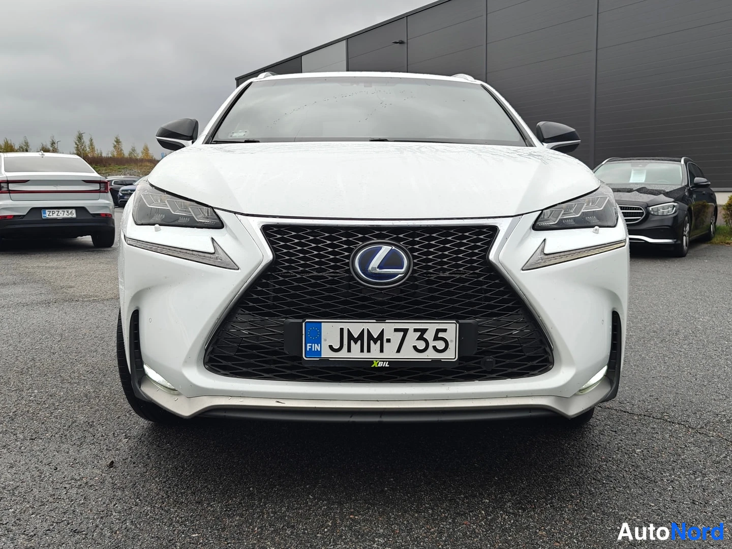 Edestä: Valkoisen Lexus NX:n etunäkymä, suuri verkkojäähdytin ja rekisterikilpi.