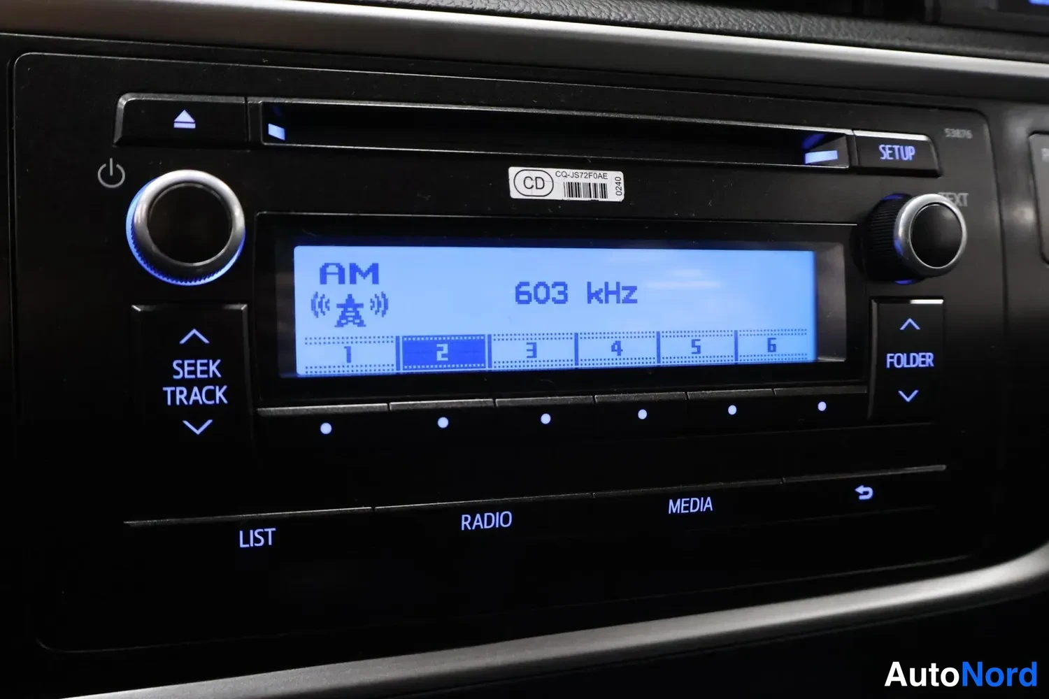 Yksityiskohta: Radio-/CD-soitin lähikuvassa, näyttö näyttää AM-taajuuden 603 kHz; näppäimistö LIST, RADIO, MEDIA, SEEK TRACK, FOLDER.