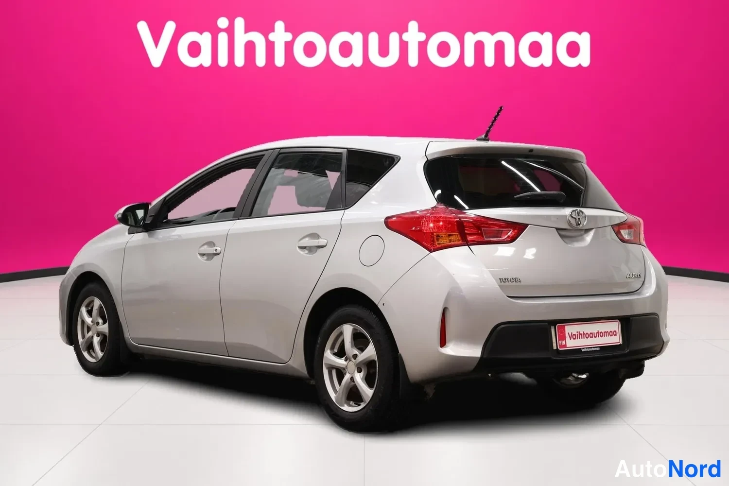 Takaviisto: Toyota Auris viistosti takaa oikealta kuvattuna, punaiset takavalot ja Vaihtoautomaan kilpi takaosassa.