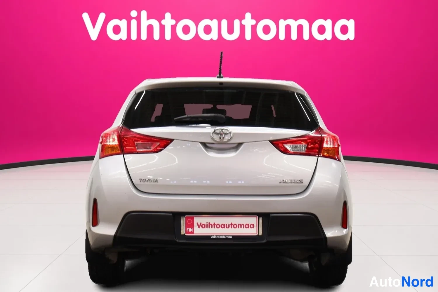 Takaa: Toyota Auris -auton takaosan suora takaa otettu näkymä, hopeanvärisen korin, takavalot ja Toyota-merkki näkyvissä.