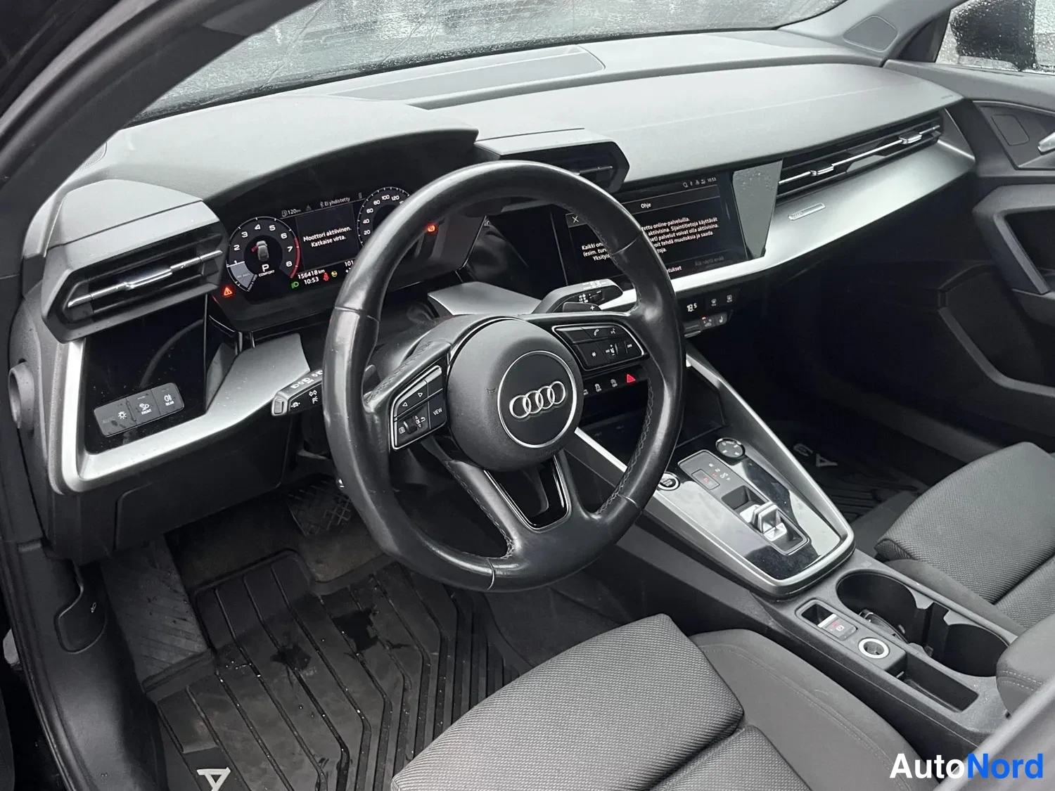 Muu: Audi-korin ohjaamo: Audi-merkkinen ohjauspyörä, digitaalinen mittaristo, keskinäytön valikko ja automaattivaihteiston valitsin.