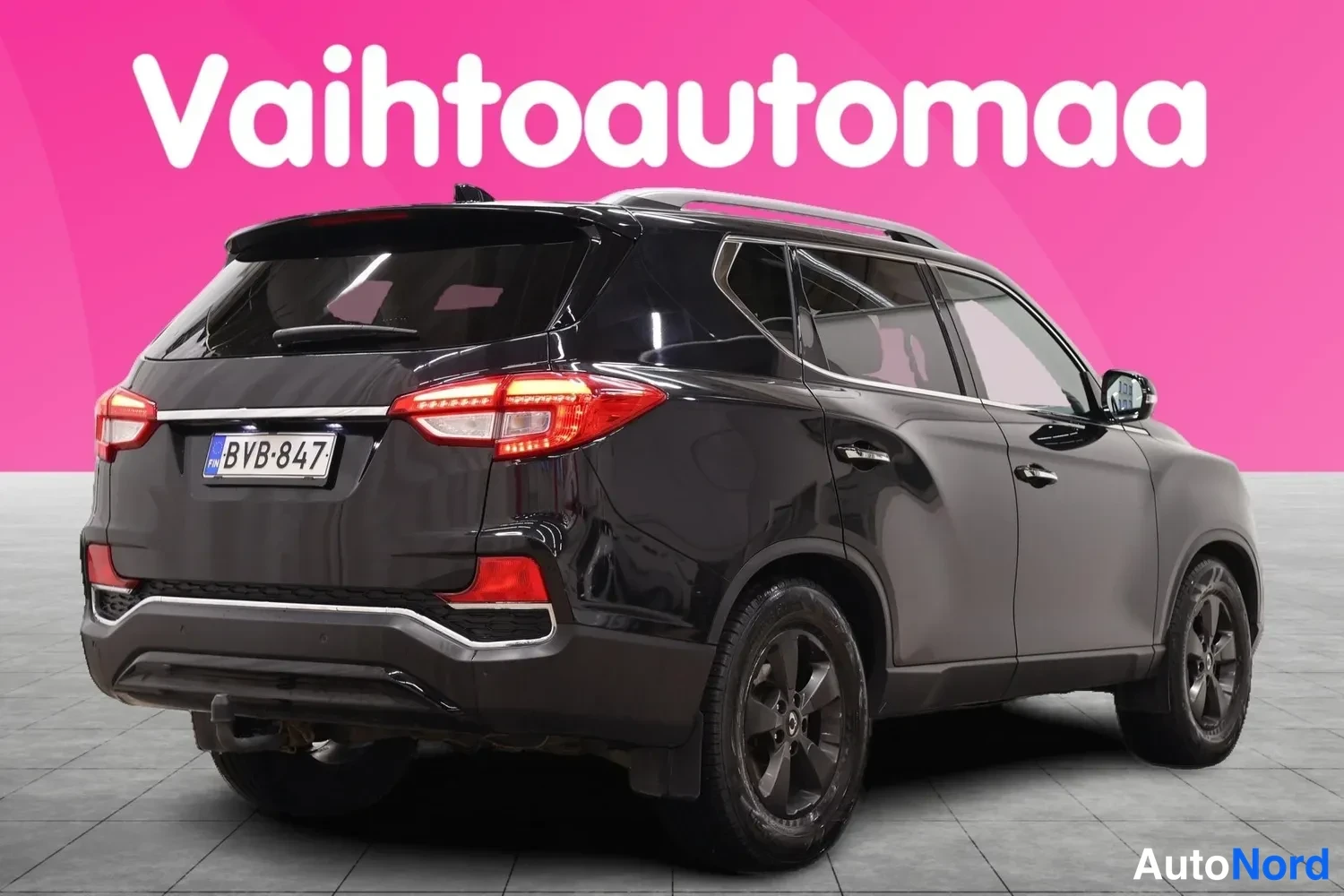 Takaviisto: Musta Ssangyong Rexton -maasturi takaa- ja sivulta kuvattuna rekisteritunnus.