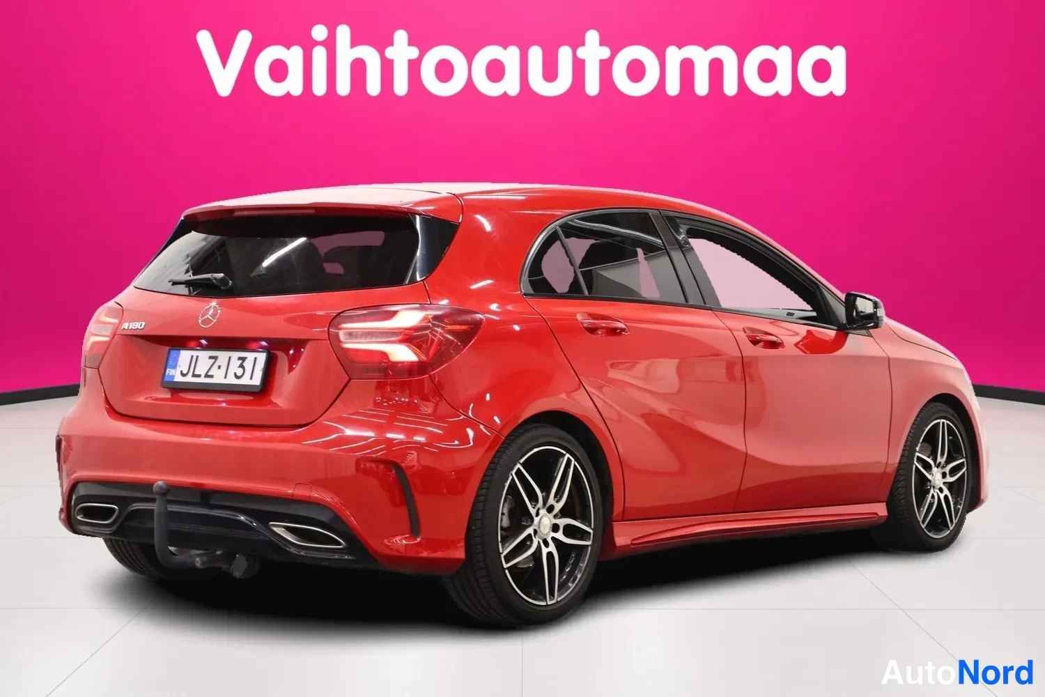 Takaviisto: Punaisen Mercedes-Benz A 180:n takakolmannes, jossa näkyvät takavalot, perävaunun rakenne ja tummat kevytmetallivanteet.