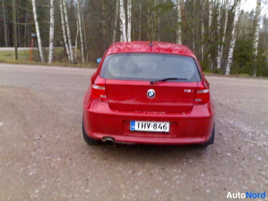 Takaa: Punainen BMW 1-sarjan farmariauto takaa kuvattuna soratiellä, rekisteritunnus 1HV-846