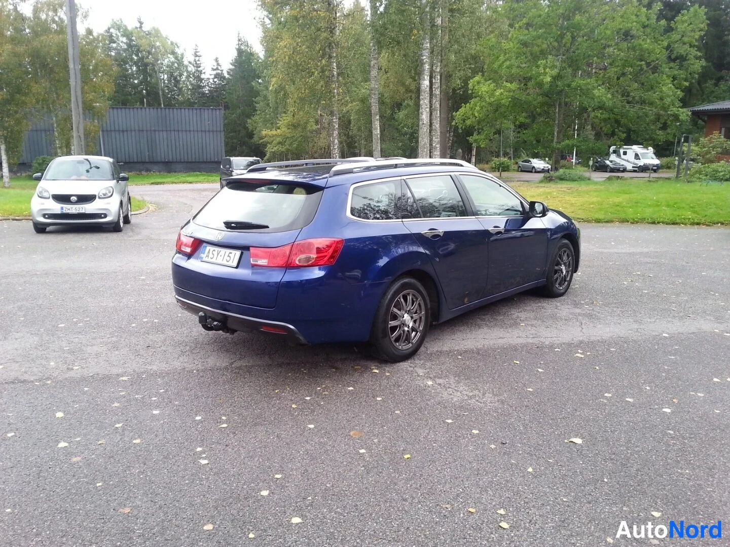 Takaviisto: Sininen Honda Accord Tourer -farmari takaviistosta vasemmalle, takana vetokoukku.