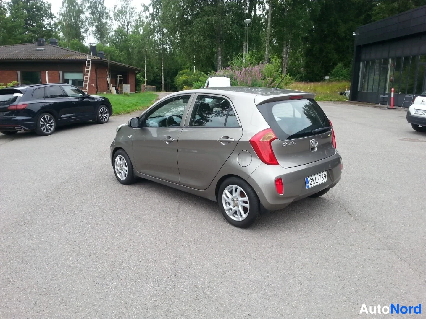 Takaviisto: Kia Picanto -henkilöauto takaa vasemmalta kulmasta nähtynä parkkipihalla.