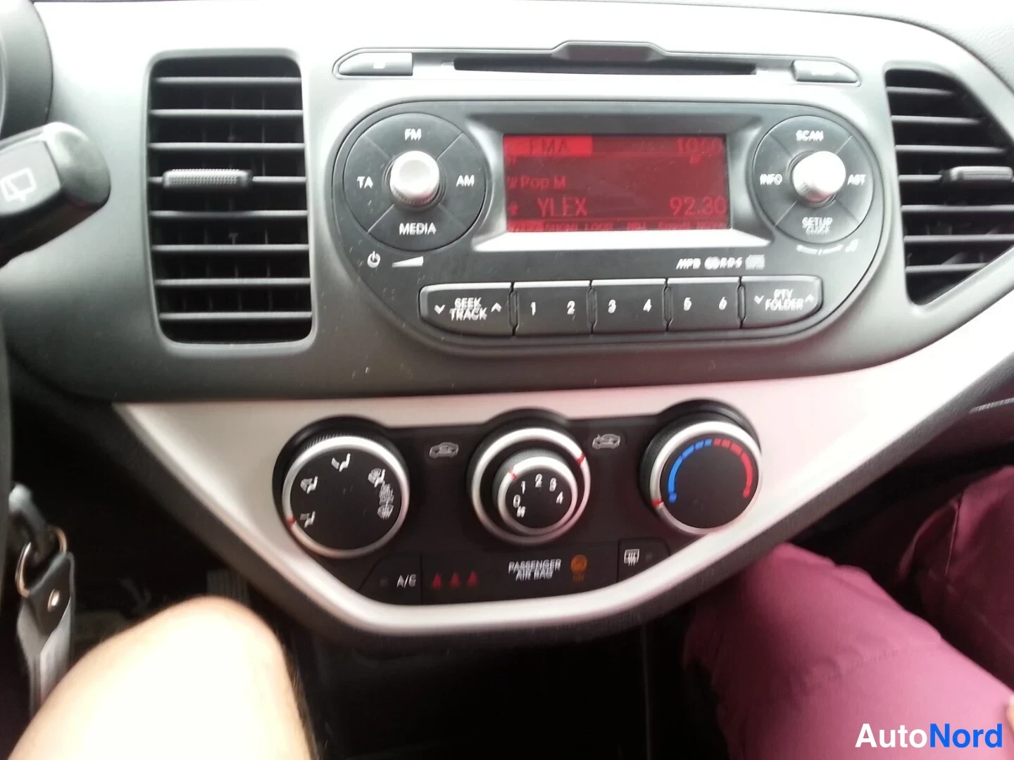 Muu: Kojelaudan keskusta: radio/CD-soitin näytöllä YLEX 92.30, esiasetusnäppäimet ja alapuolella kolme lämmityksen säätönuppia; A/C-painike ja PASSANGER AIR BAG -mer
