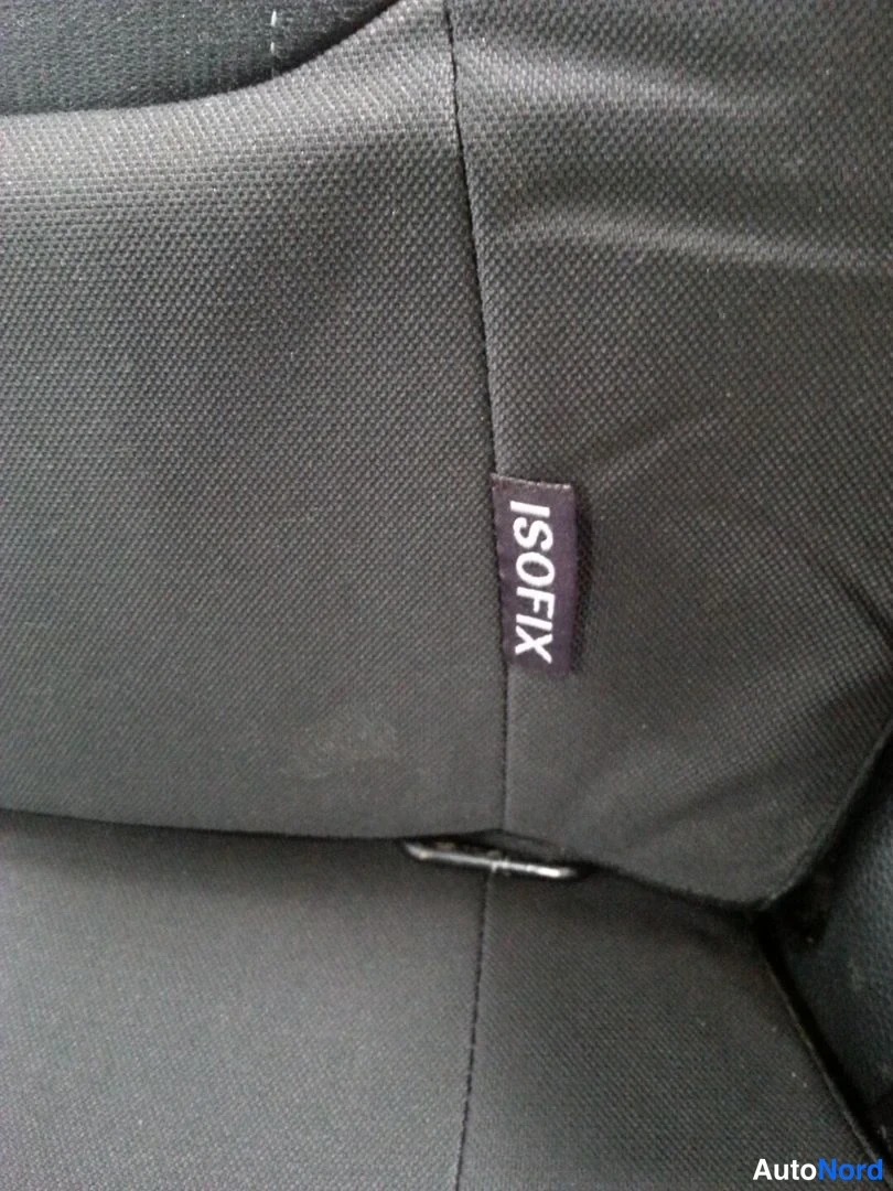 Muu: Lähikuva harmaasta kankaanverhouksesta, jossa lukee 'ISOFIX' -nimikke.