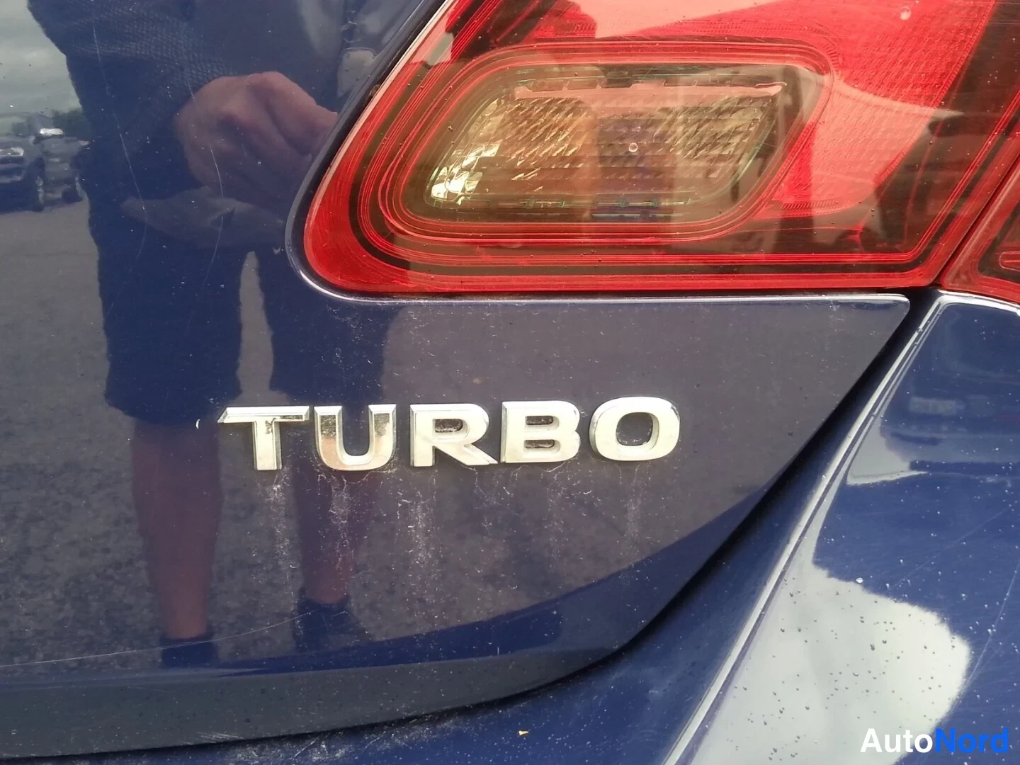Yksityiskohta: Lähikuva tummansinisestä autosta, missä lukee TURBO takalampun alla.