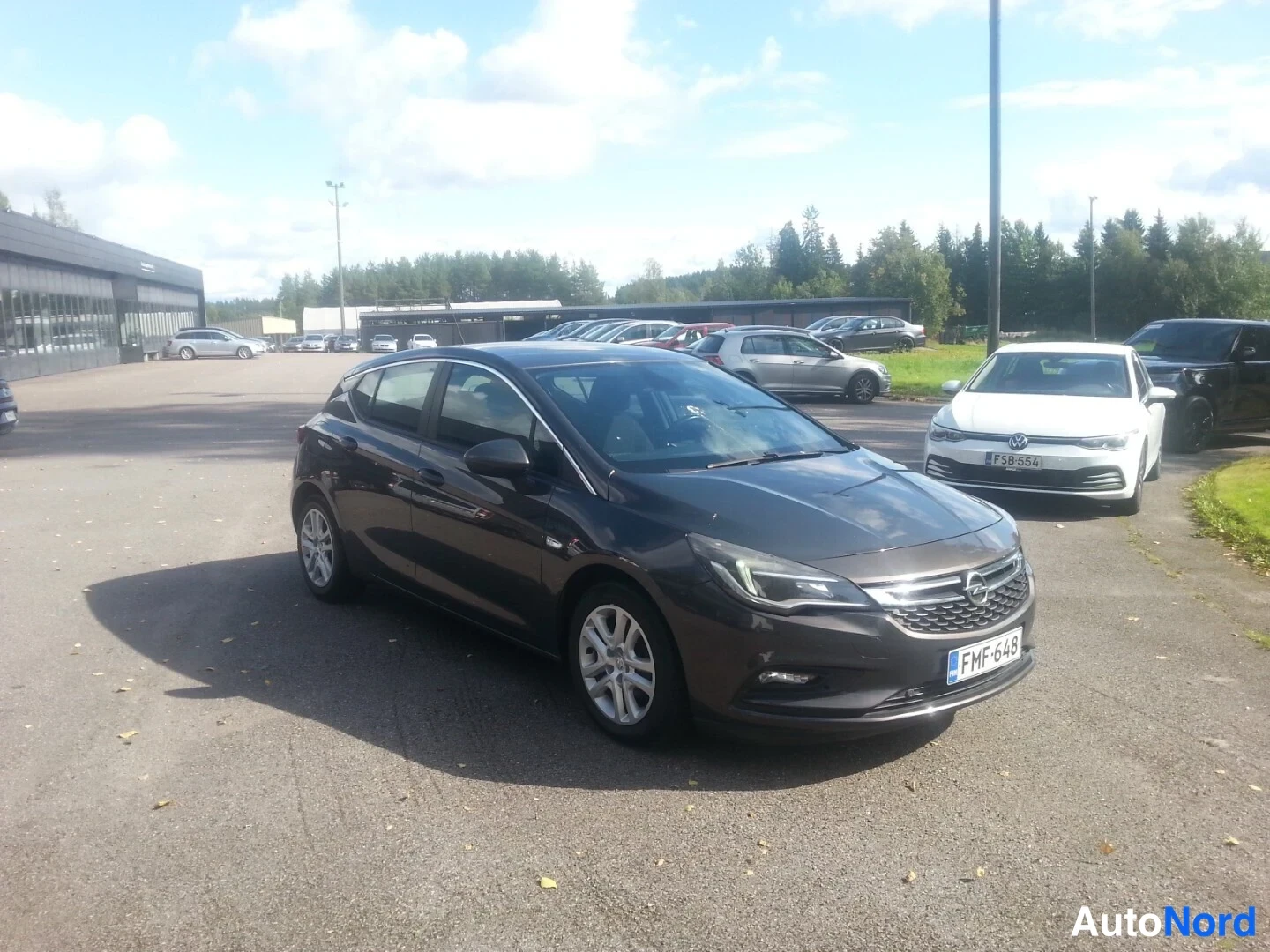 Etuviisto, nokka oikealle: Tummanharmaa hatchback kolmanneltakulmasta keulaa oikealle kääntyneenä, rekisteritunnus.