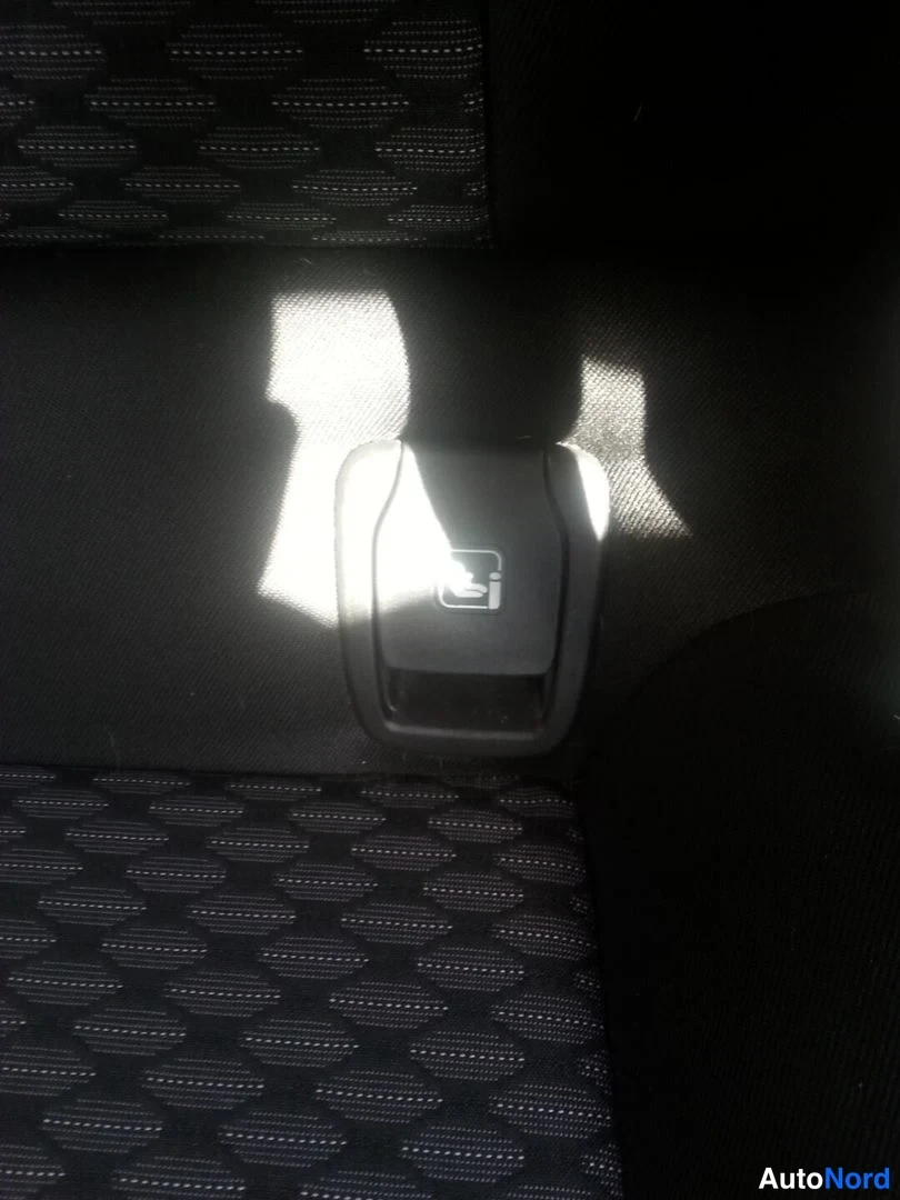Muu: Kuva istuimen rakenteesta, jonka selkänojan alaosassa on i-Size-merkitty istuimen kiinnityspidike (ISOFIX-merkintä).