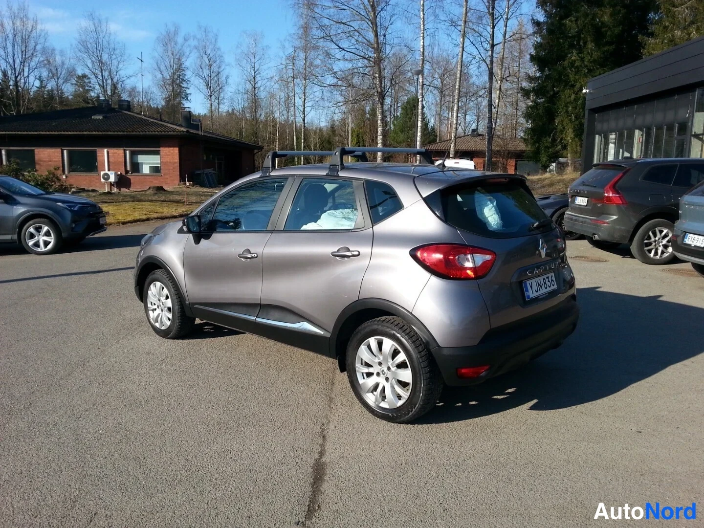 Takaviisto: Renault Captur -auto takakolmannesta, hopeanharmaa kori, kattokaiteet ja takavalot näkyvät, rekisterikilpi.