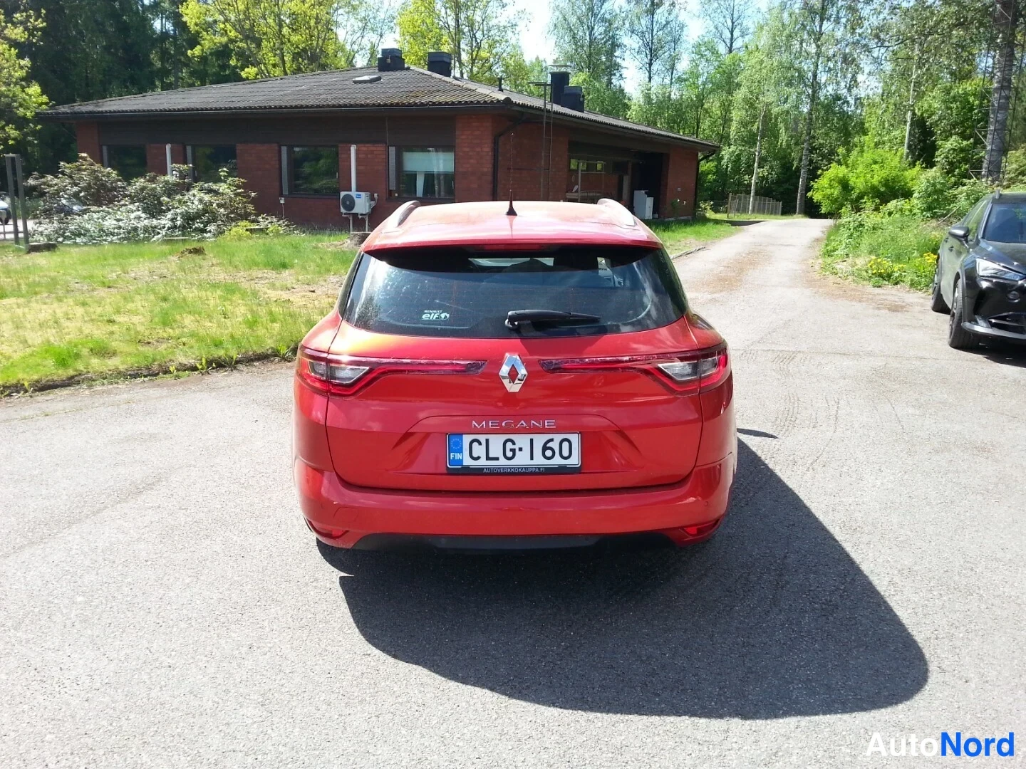Takaa: Punaisen Renault Megane Sport Tourer -farmarin takaosa suoraan takaa; rekisterikilpi.