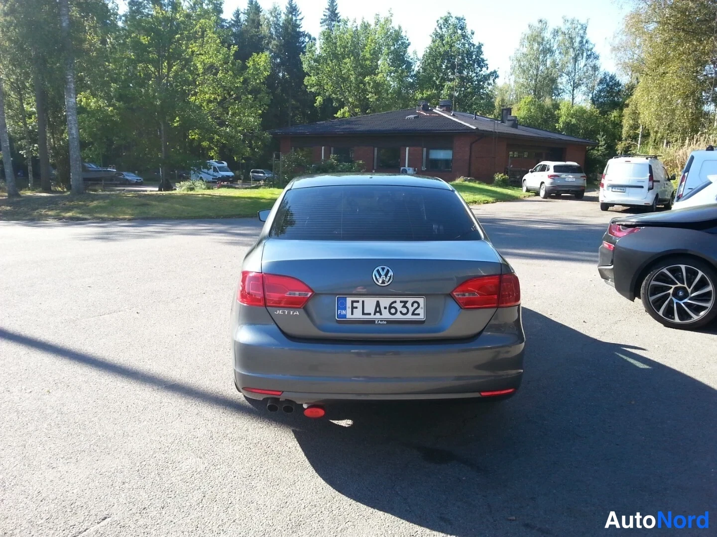 Takaa: Volkswagen Jetta takaa päin, rekisterikilpi, JETTA-teksti ja takavalot näkyvät pihamaalla.