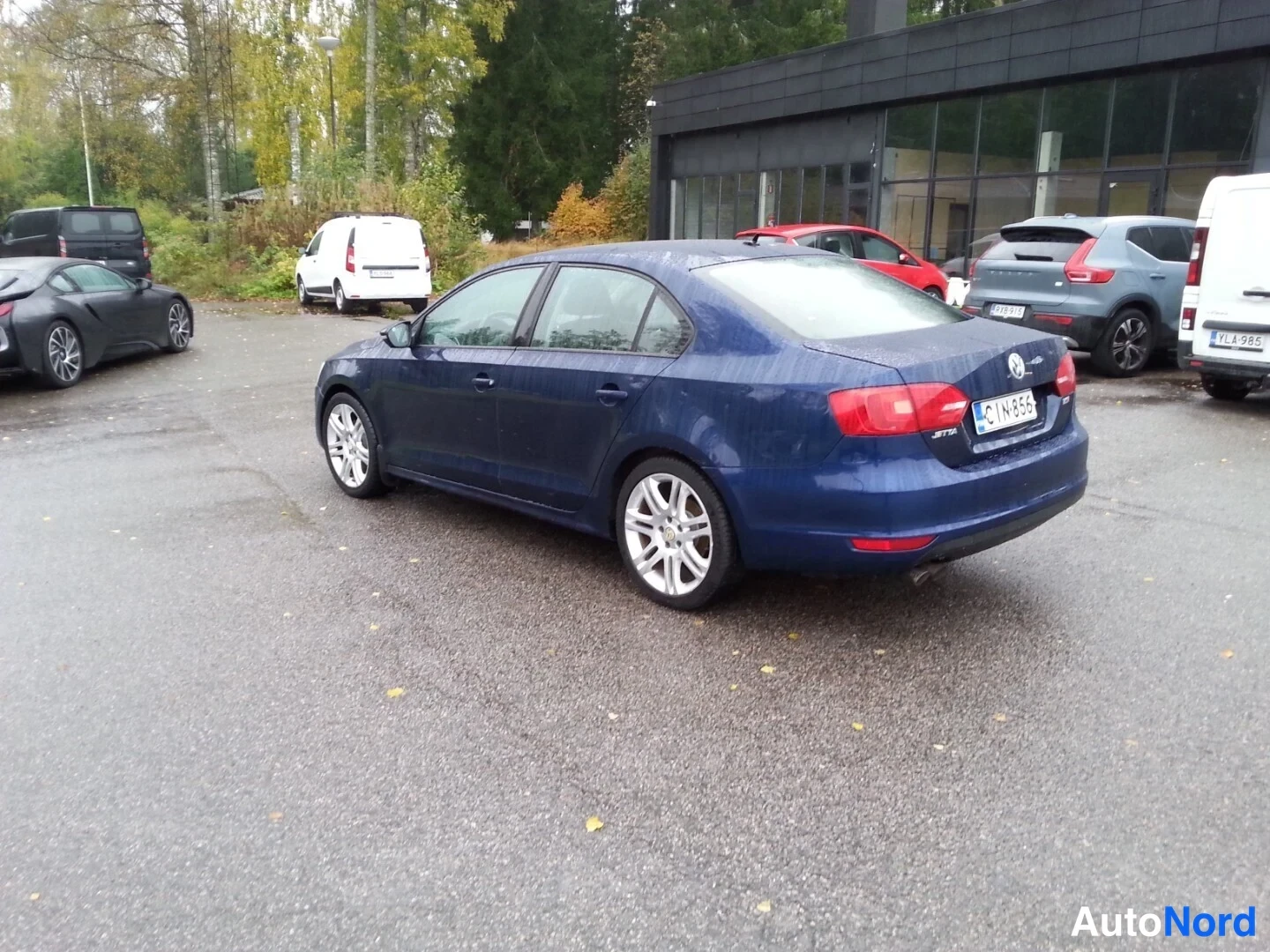 Takaviisto: Tummansininen Volkswagen Jetta -sedan vinosti takaa oikealta kuvattuna parkkipaikalla rekisterikilpi CN-856.