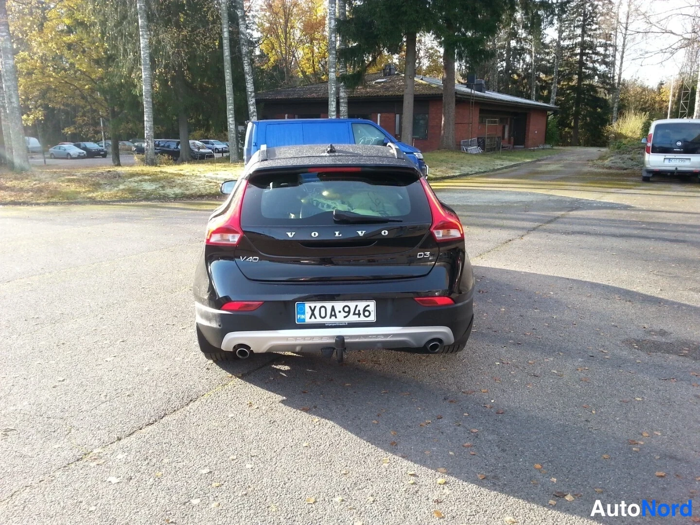 Takaa: Mustan Volvon takapää, rekisterikilpi, takavalojen välissä VOLVO-teksti, peräoveen merkitty V40 ja D3.