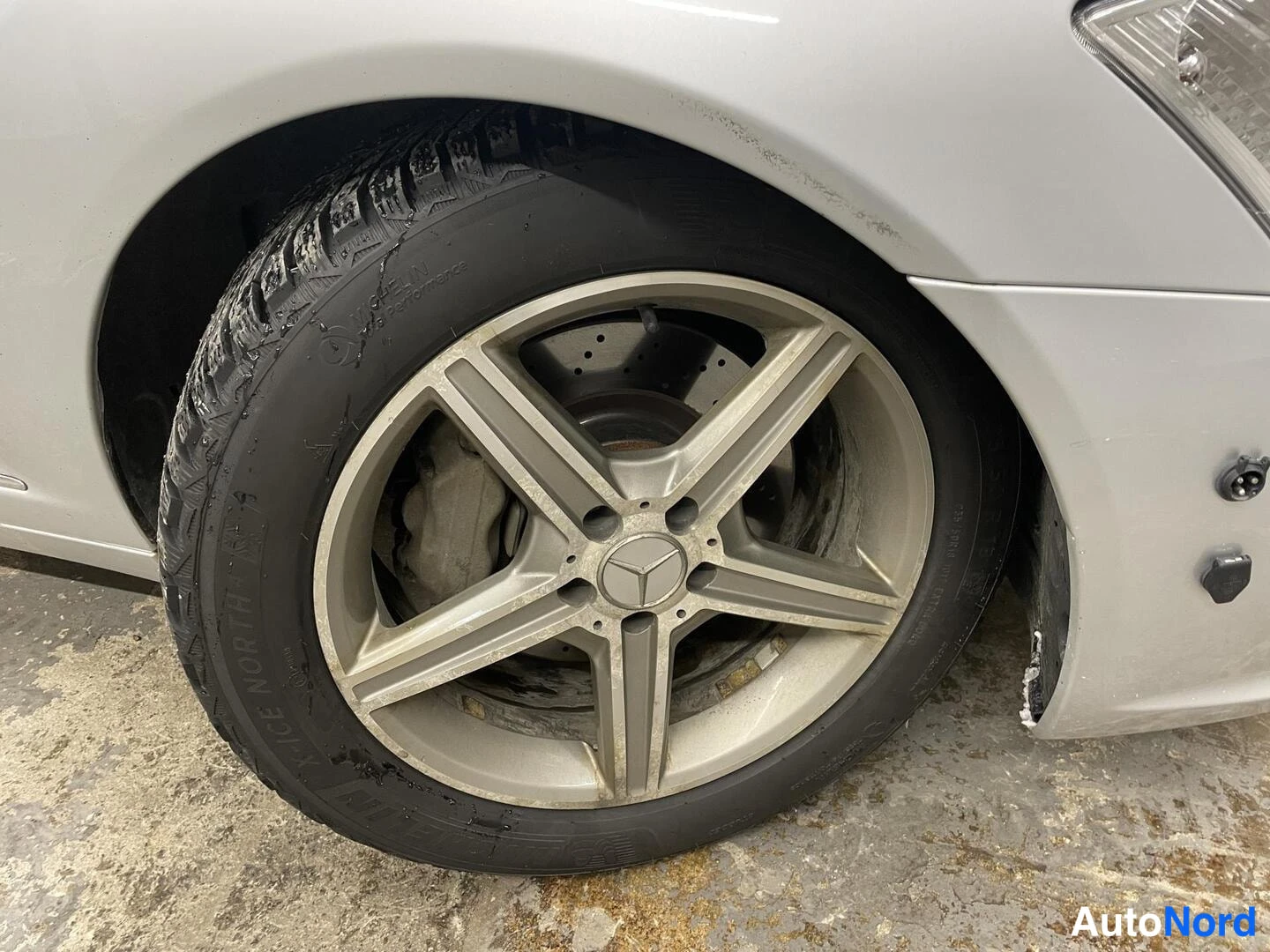 Muu: Lähikuva autojen kevytmetallivanteesta ja talvirenkaasta.